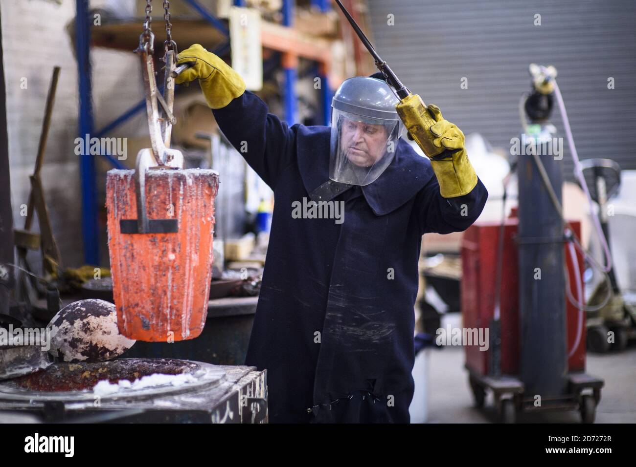 Furnace man Billy Smith prepares molten bronze during the making of Bafta awards, at a foundry in West Drayton, Middlesex, ahead of the award ceremony in February. Designed by US sculptor Mitzi Cunliffe, New Pro Foundries has been making the bronze casts since the ceremony was created in 1976. Picture date: Tuesday January 31, 2016. Photo credit should read: Matt Crossick/ EMPICS Entertainment. Stock Photo