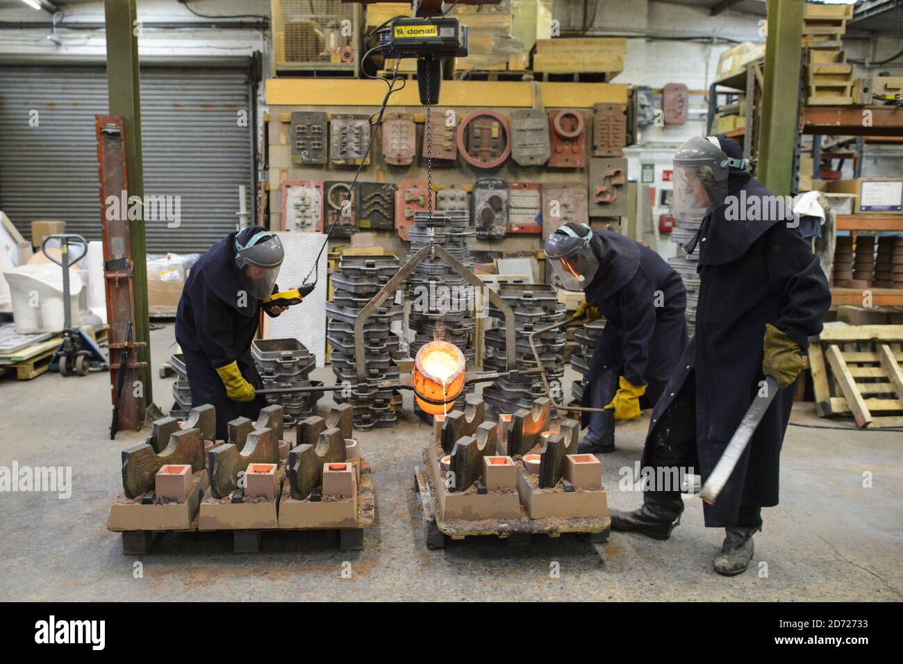 Molten bronze is poured into casts during the making of Bafta awards, at a foundry in West Drayton, Middlesex, ahead of the award ceremony in February. Designed by US sculptor Mitzi Cunliffe, New Pro Foundries has been making the bronze casts since the ceremony was created in 1976. Picture date: Tuesday January 31, 2016. Photo credit should read: Matt Crossick/ EMPICS Entertainment. Stock Photo