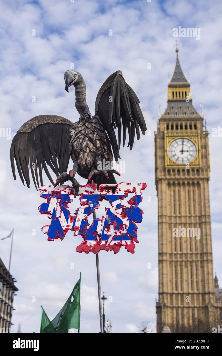 A sign depicting a vulture over the NHS, as demonstrators attend a rally in Parliament Square, London, protesting against cuts and underfunding in the NHS. Picture date: Saturday March 4th, 2016. Photo credit should read: Matt Crossick/ EMPICS Entertainment. Stock Photo