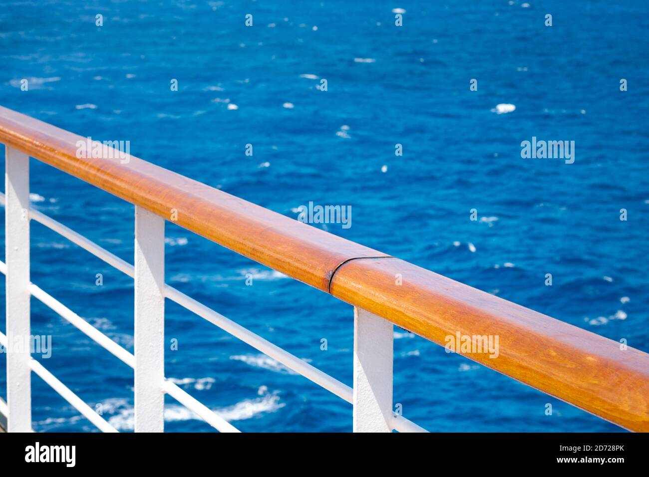 Cruising, relaxation at sea and maritime travel by cruise ship concept with a peaceful scene of a handrail with nobody around it, overlooking the tran Stock Photo