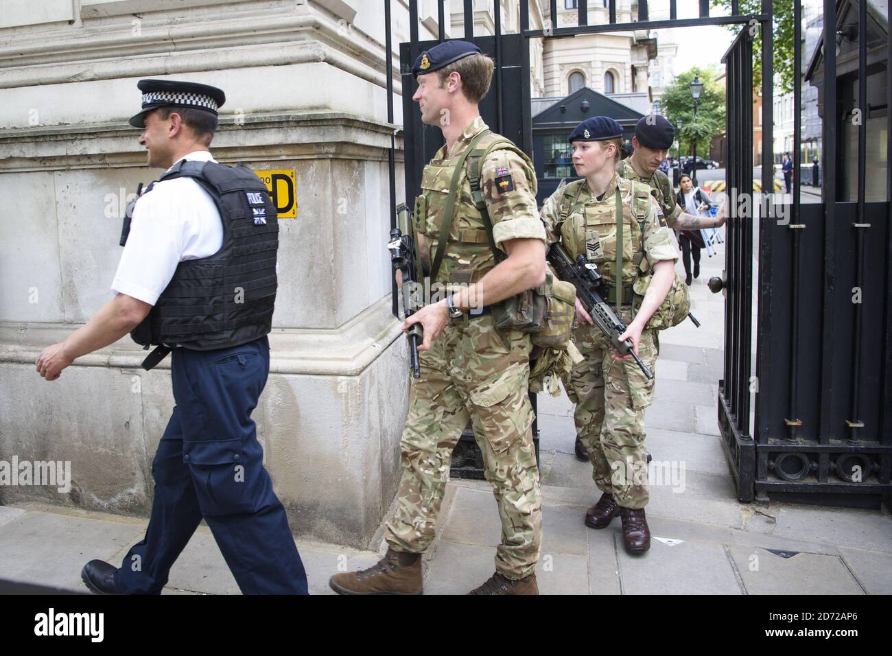 Members of the army join police officers outside Downing Street, London, after Scotland Yard announced armed troops will be deployed to guard "key locations" such as Buckingham Palace, Downing Street, the Palace of Westminster and embassies. Picture date: Wednesday May 24th, 2017. Photo credit should read: Matt Crossick/ EMPICS Entertainment. Stock Photo