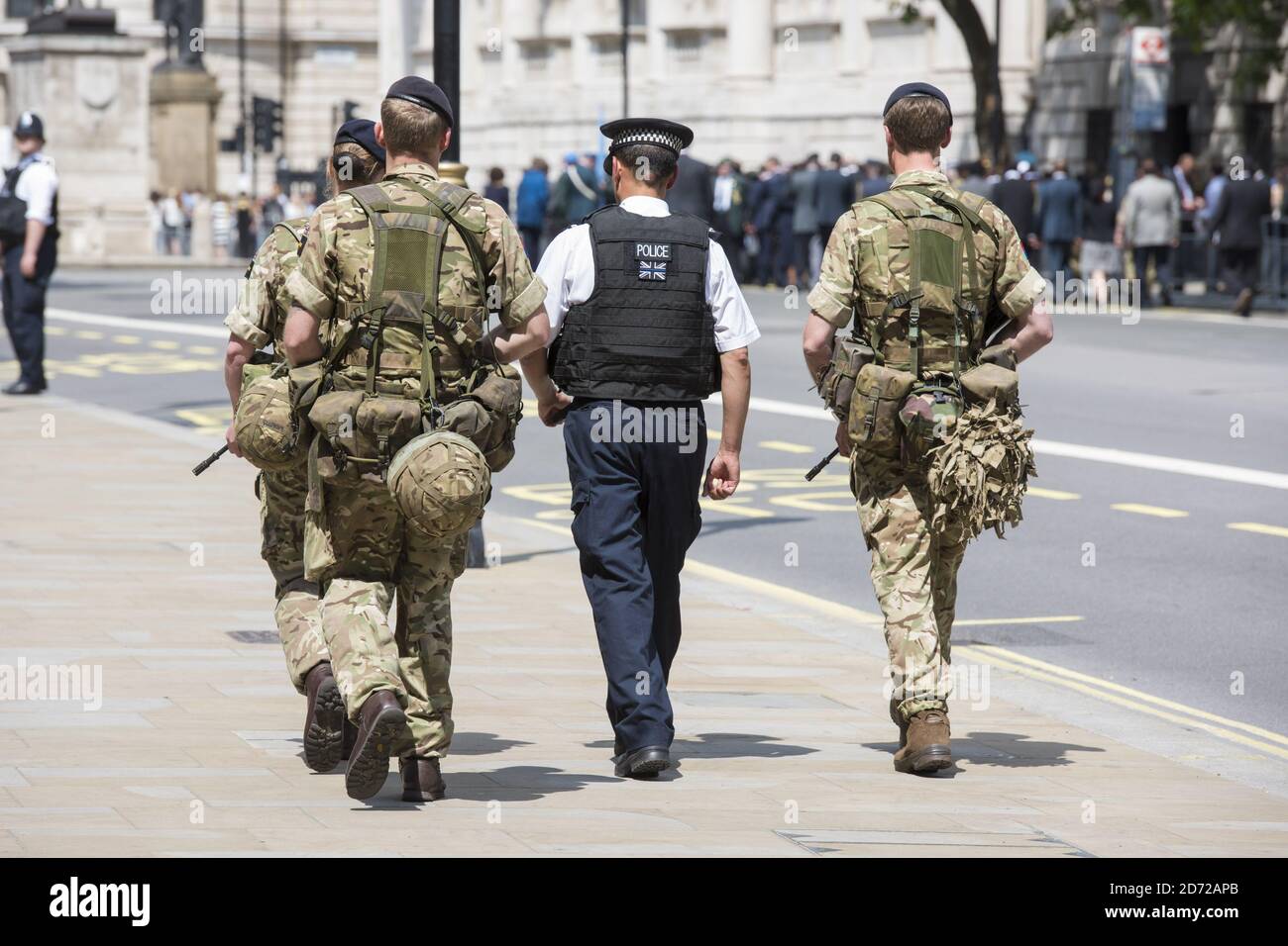 Members of the army join police officers on Whitehall, London, after Scotland Yard announced armed troops will be deployed to guard 'key locations' such as Buckingham Palace, Downing Street, the Palace of Westminster and embassies. Picture date: Wednesday May 24th, 2017. Photo credit should read: Matt Crossick/ EMPICS Entertainment. Stock Photo