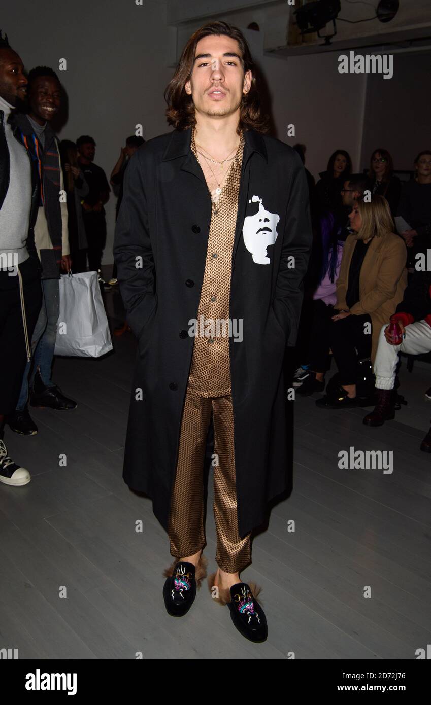 Hector Bellerin wears a Neil Barrett jacket, Zimmermann pyjamas and Gucci  shoes on the front row during the Bobby Abley London Fashion Week Men's  AW18 show, held at the BFC Show Space,