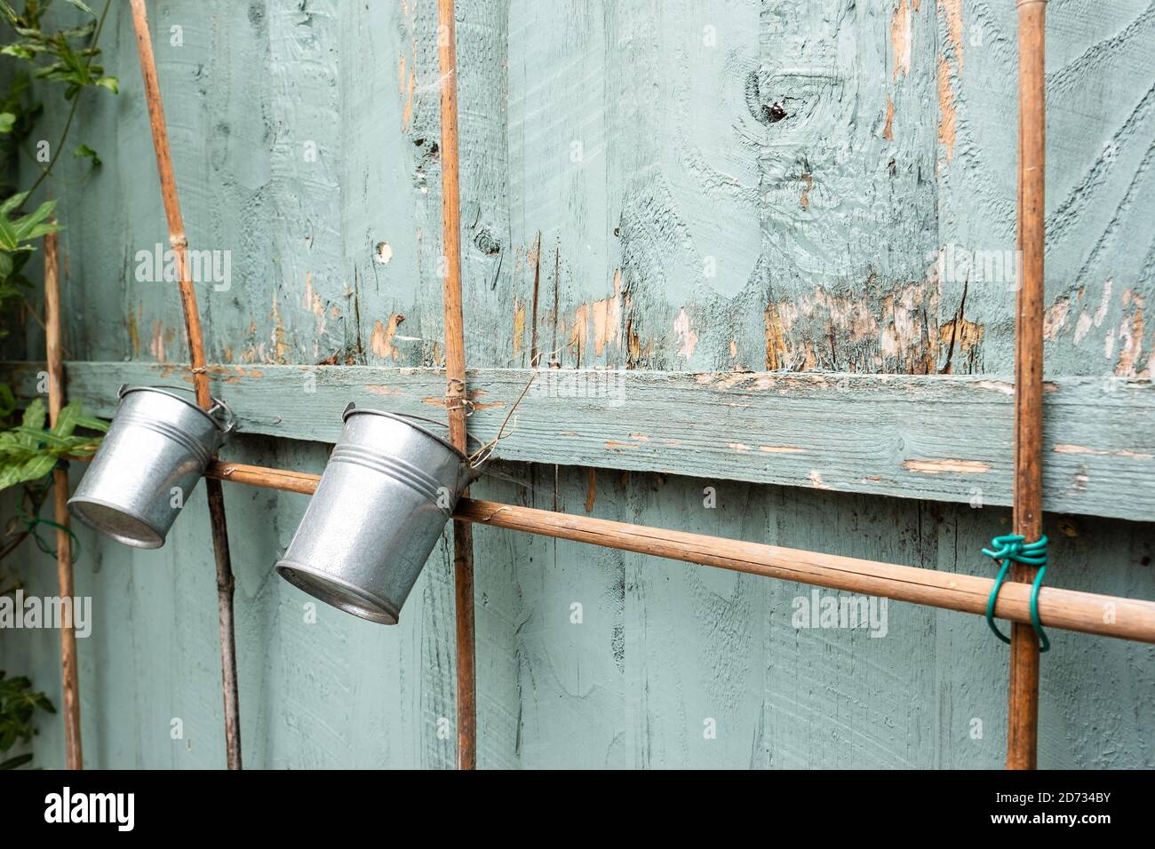 Shallow focus of small miniature buckets seen hanging off garden canes