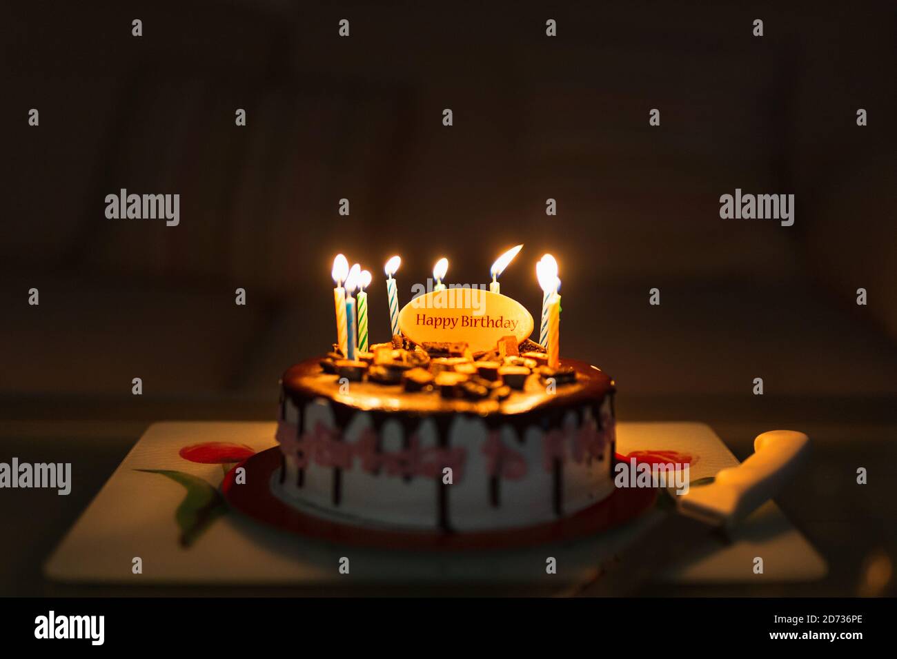 Birthday cake on black background with colorful candles lit Stock Photo ...