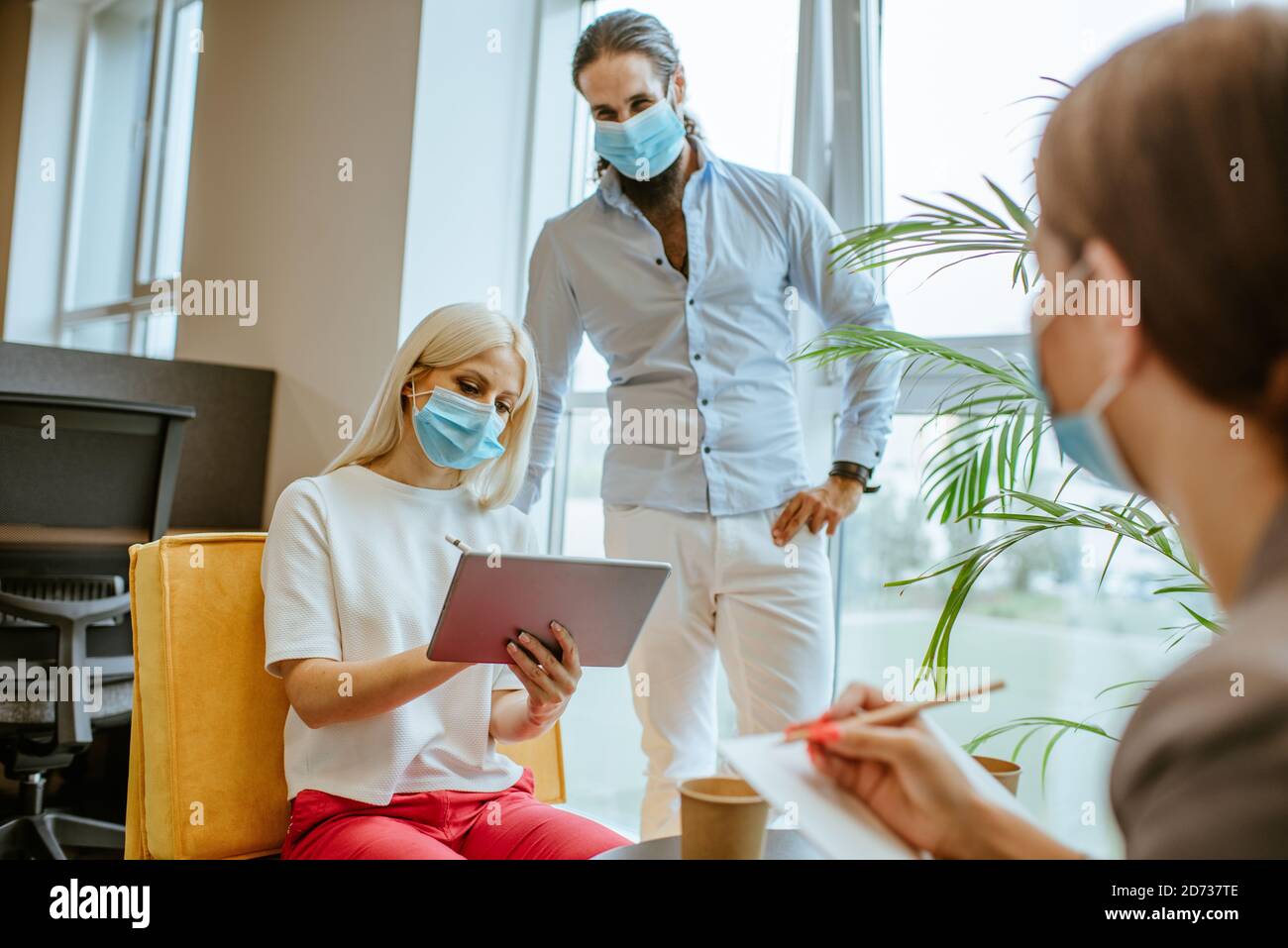 Business people in protective medical masks discussing Stock Photo