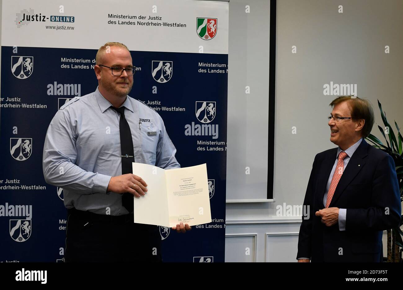 Duesseldorf, Germany. 20th Oct, 2020. Peter Biesenbach (CDU, r) Minister of Justice of North Rhine-Westphalia, thanks Daniel Freihoff (l) with a certificate and a shopping voucher for his efforts. At the beginning of September, an employee of Kleve Prison rescued a small child from the right-hand lane of Autobahn 3 who had left the nearby rest area unnoticed by his parents and ran onto the road. Credit: Roberto Pfeil/dpa/Alamy Live News Stock Photo