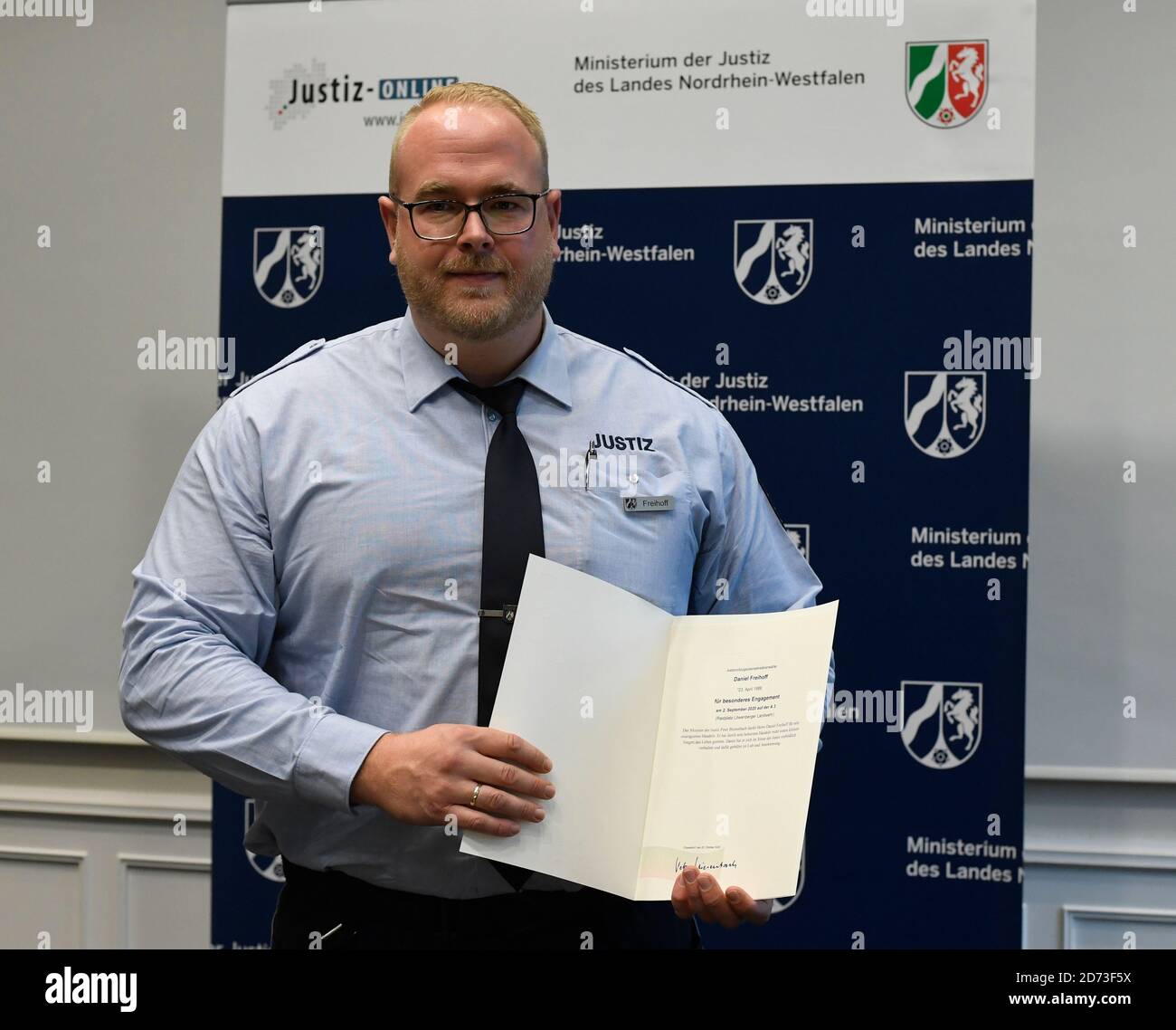 Duesseldorf, Germany. 20th Oct, 2020. Daniel Freihoff shows his certificate, which he received from the Minister of Justice of North Rhine-Westphalia for his efforts. At the beginning of September, an employee of the Kleve Prison rescued a small child from the right-hand lane of Autobahn 3 who had left the nearby rest area unnoticed by his parents and ran onto the road. Credit: Roberto Pfeil/dpa/Alamy Live News Stock Photo