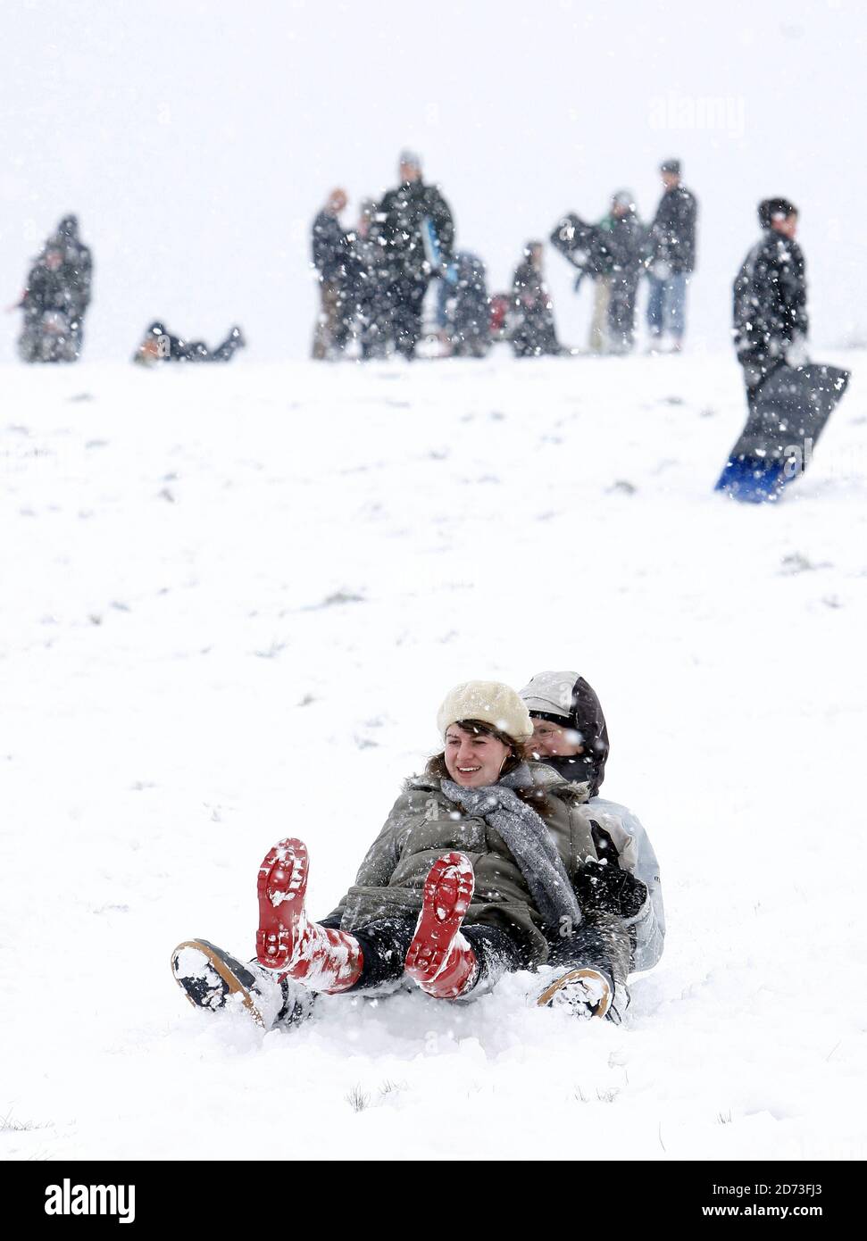 People toboggan on Hampstead Heath after heavy snow shuts schools and