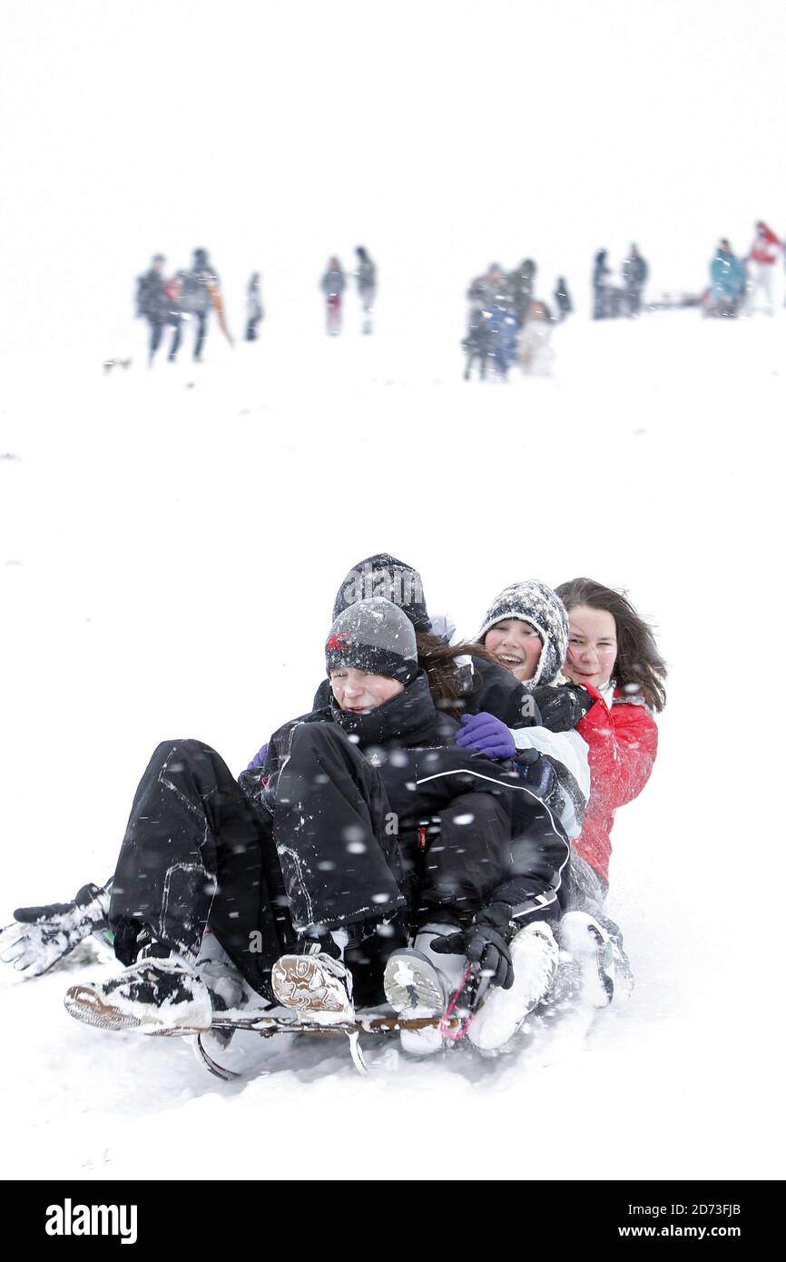 People toboggan on Hampstead Heath after heavy snow shuts schools and