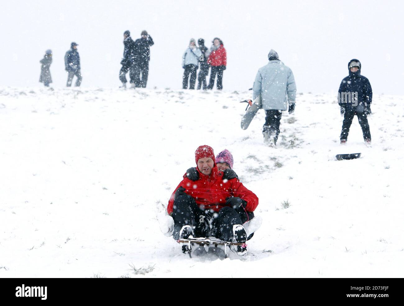 People toboggan on Hampstead Heath after heavy snow shuts schools and