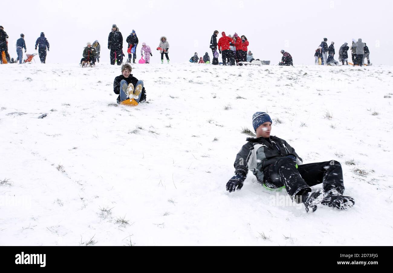 People toboggan on Hampstead Heath after heavy snow shuts schools and