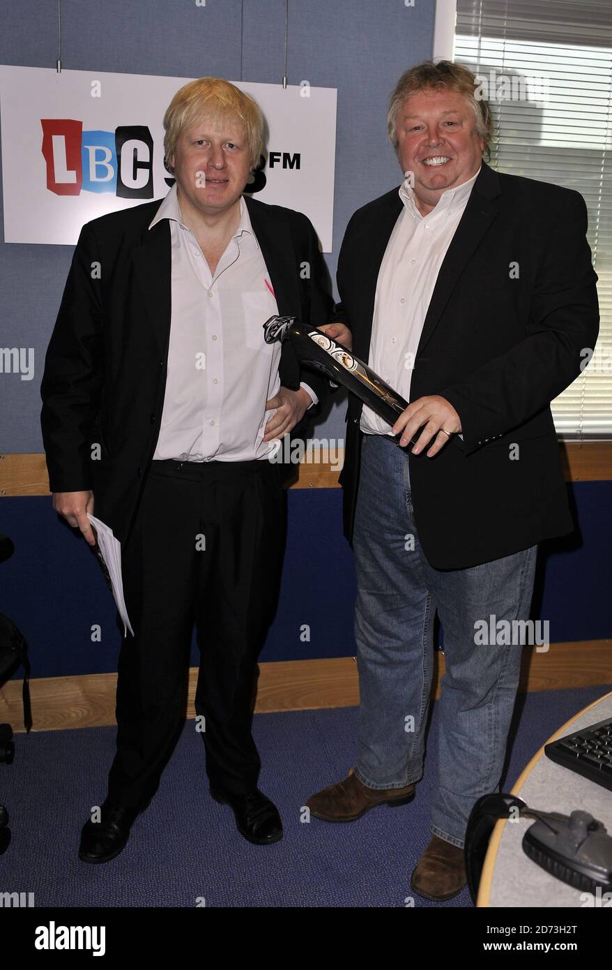 Boris Johnson being presented with a mudguard for his bike, by LBC DJ NIck Ferrari, after an interview on the radio station's breakfast show at their studio in Leicester Square, London. Stock Photo
