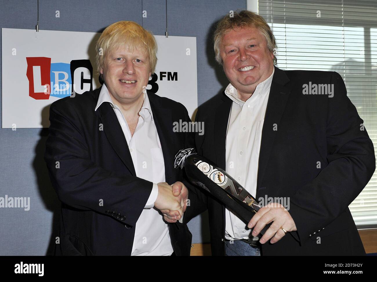 Boris Johnson being presented with a mudguard for his bike, by LBC DJ NIck Ferrari, after an interview on the radio station's breakfast show at their studio in Leicester Square, London. Stock Photo