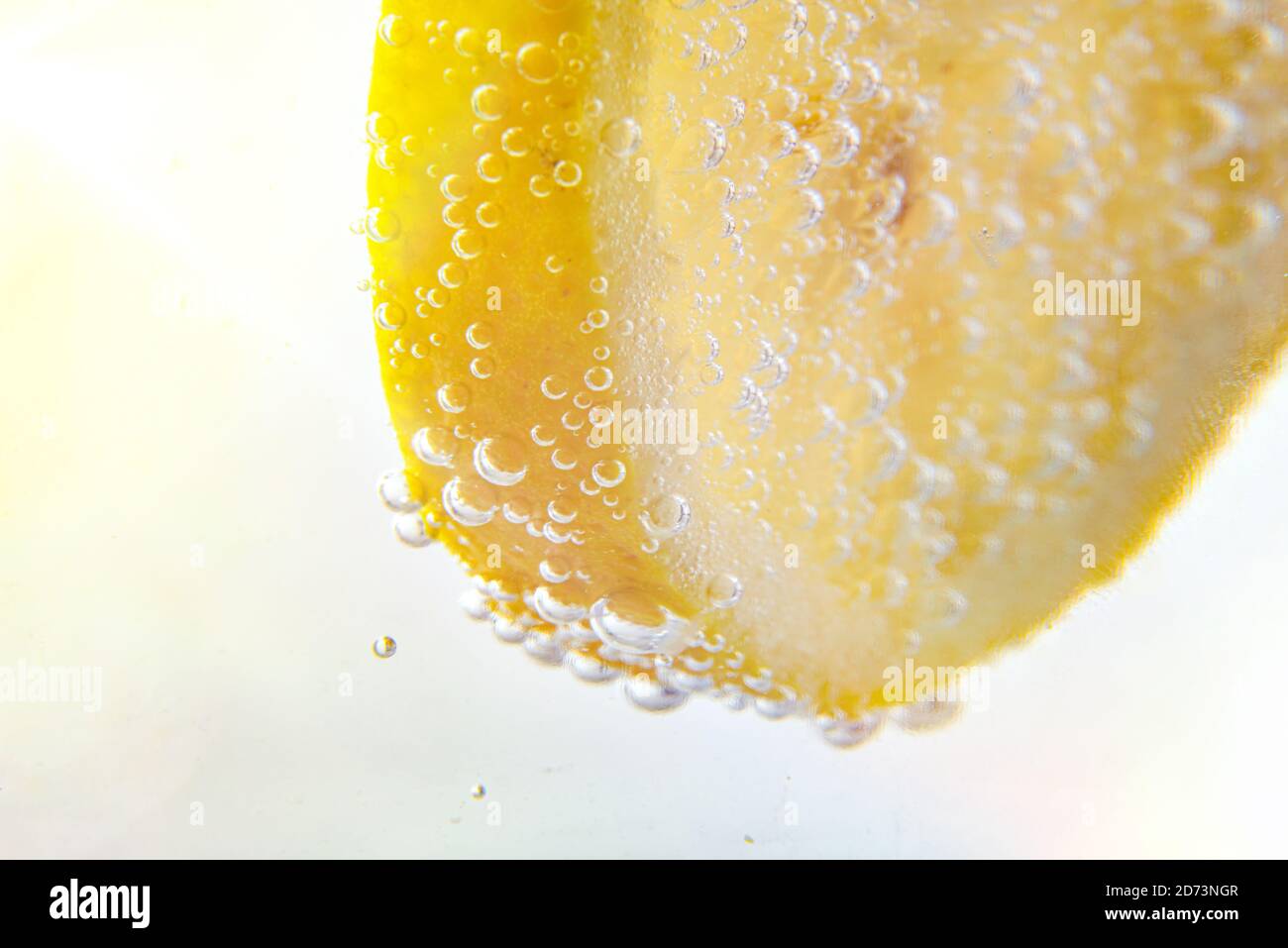 Detail of lemon dipped in water full of bubbles close up Stock Photo
