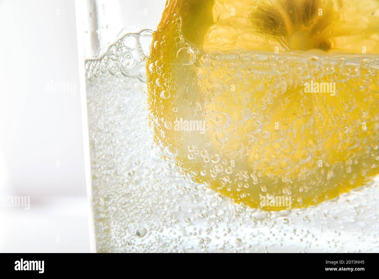 Detail of glass with sparkling water and lemon slice front view Stock Photo