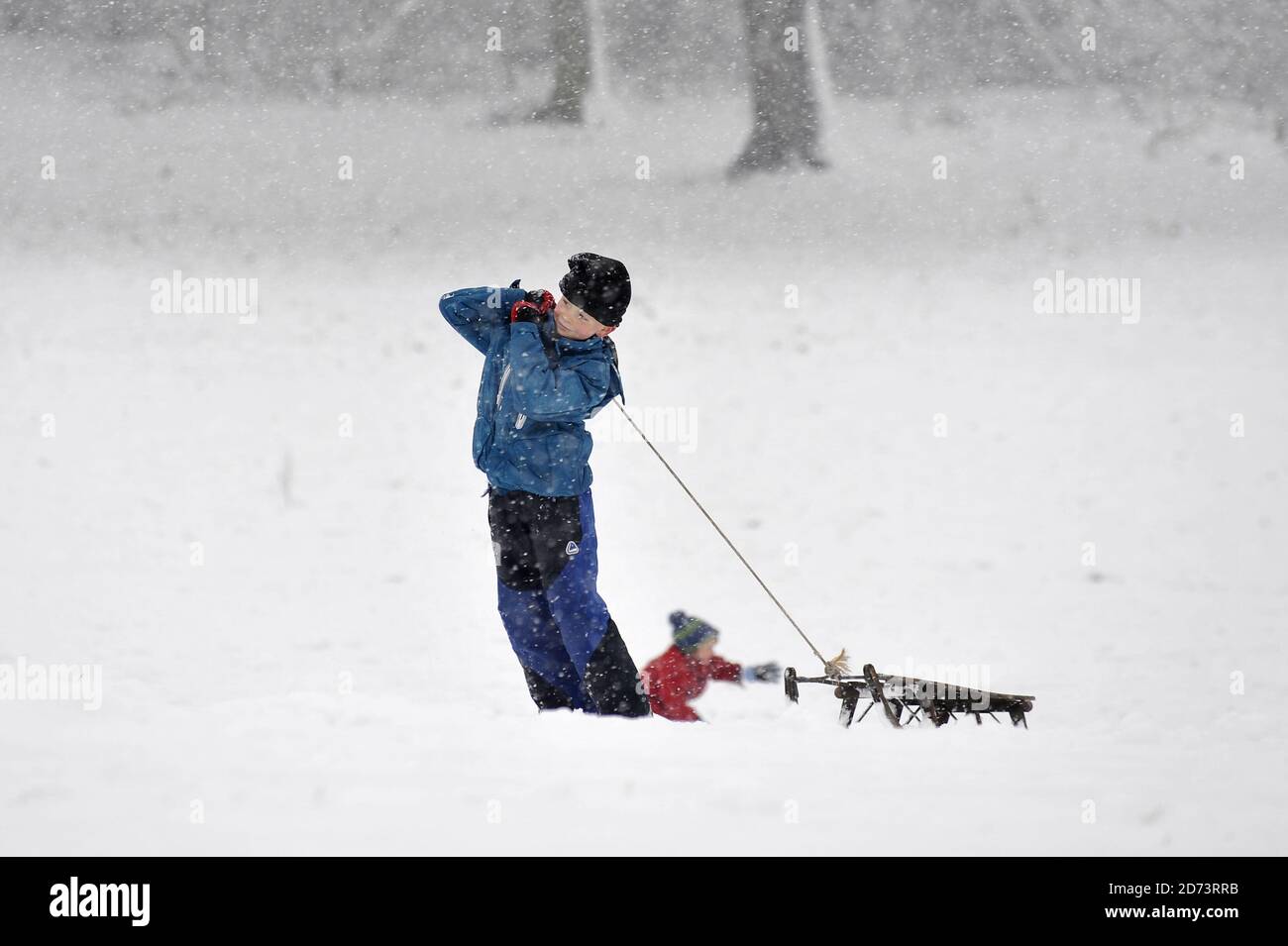 Children toboggan as Hampstead Heath lies covered in snow as a cold