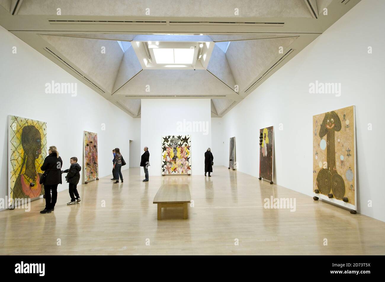 Visitors look at works by Chris Ofili on display at a new exhibition of ...