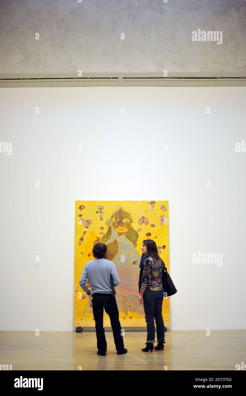 Visitors look at works by Chris Ofili on display at a new exhibition of ...