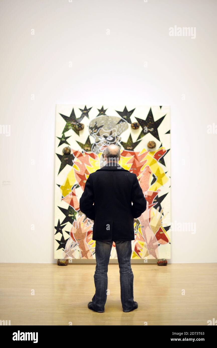 Visitors look at works by Chris Ofili on display at a new exhibition of ...