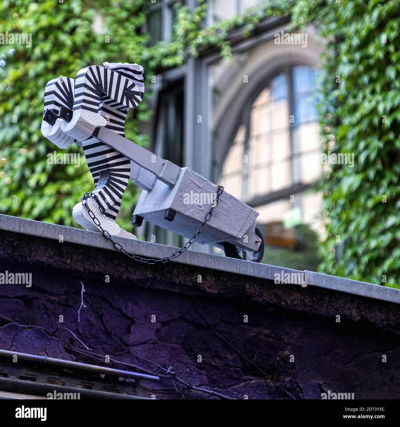 Street art sculpture of chained convict pushing wheelbarrow at Haus Schwarzenberg , 39 Rosenthaler Strasse, Mitte, Berlin. Stock Photo