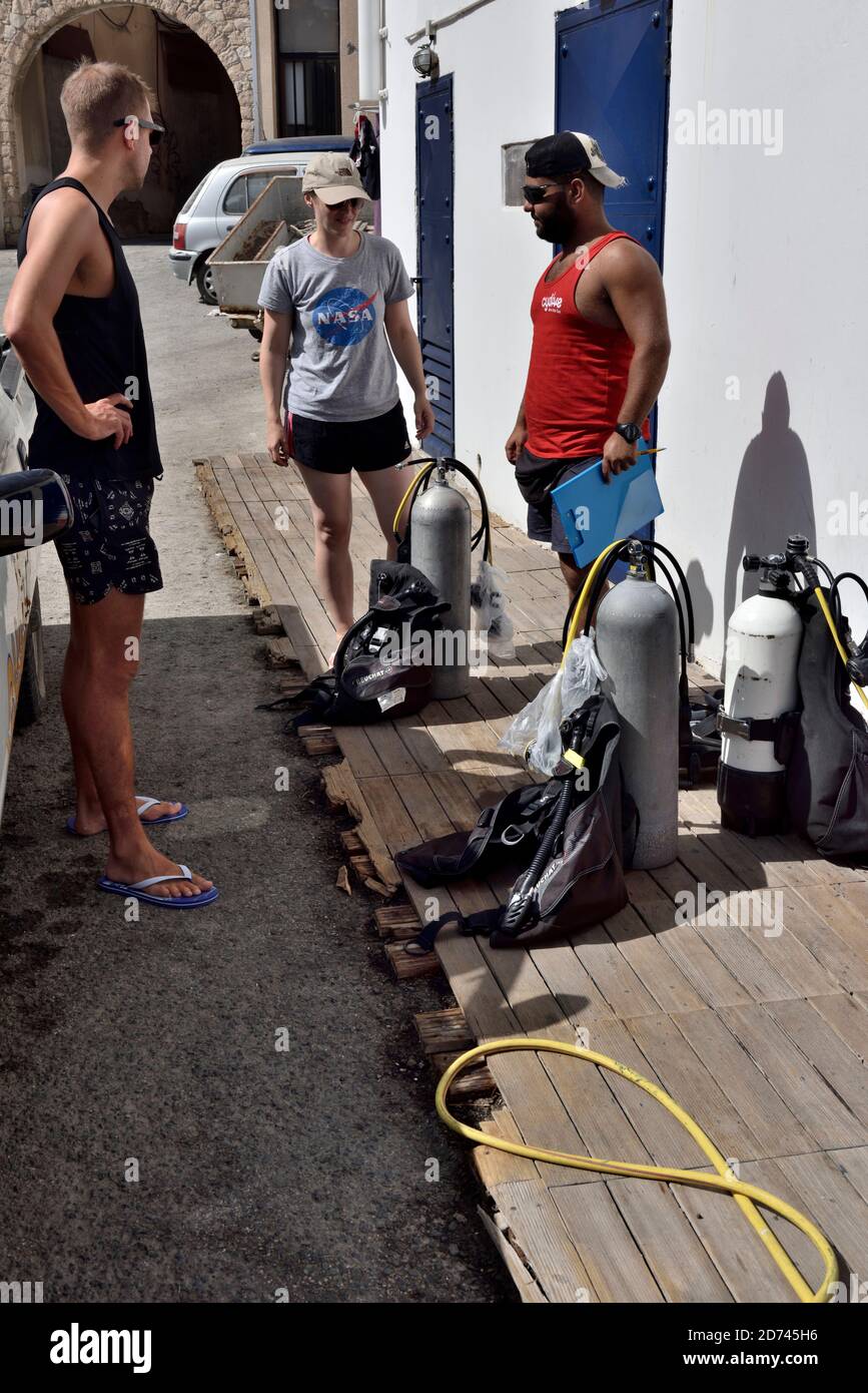 Scuba diving tourists preparing tanks at dive shop, Paphos, Cyprus Stock Photo