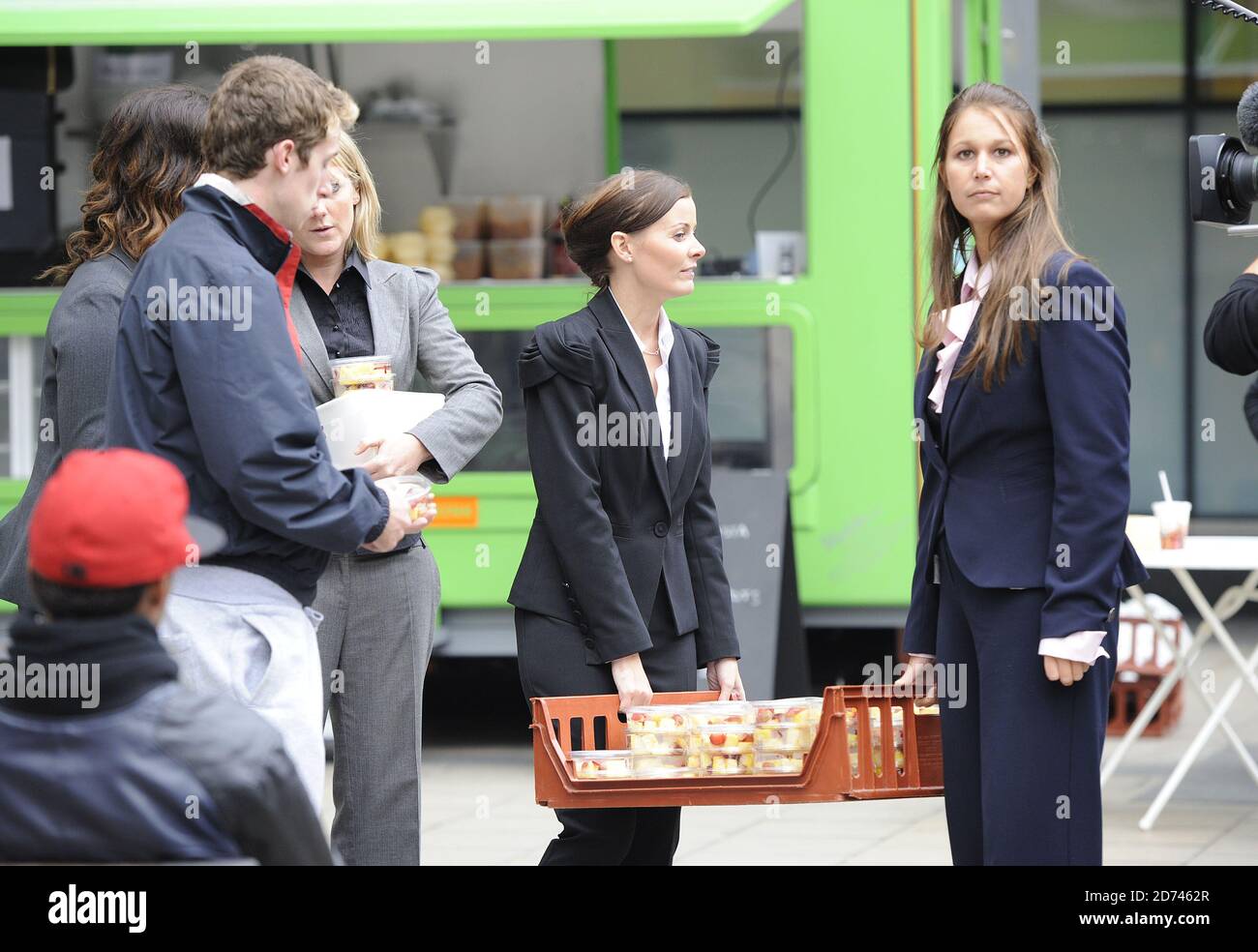 The Apprentice contestants Joanna Riley, Liz Locke and Laura Moore are seen during filming at Euston station, central London, where they were selling vegetarian meals and fresh fruit to commuters. Stock Photo