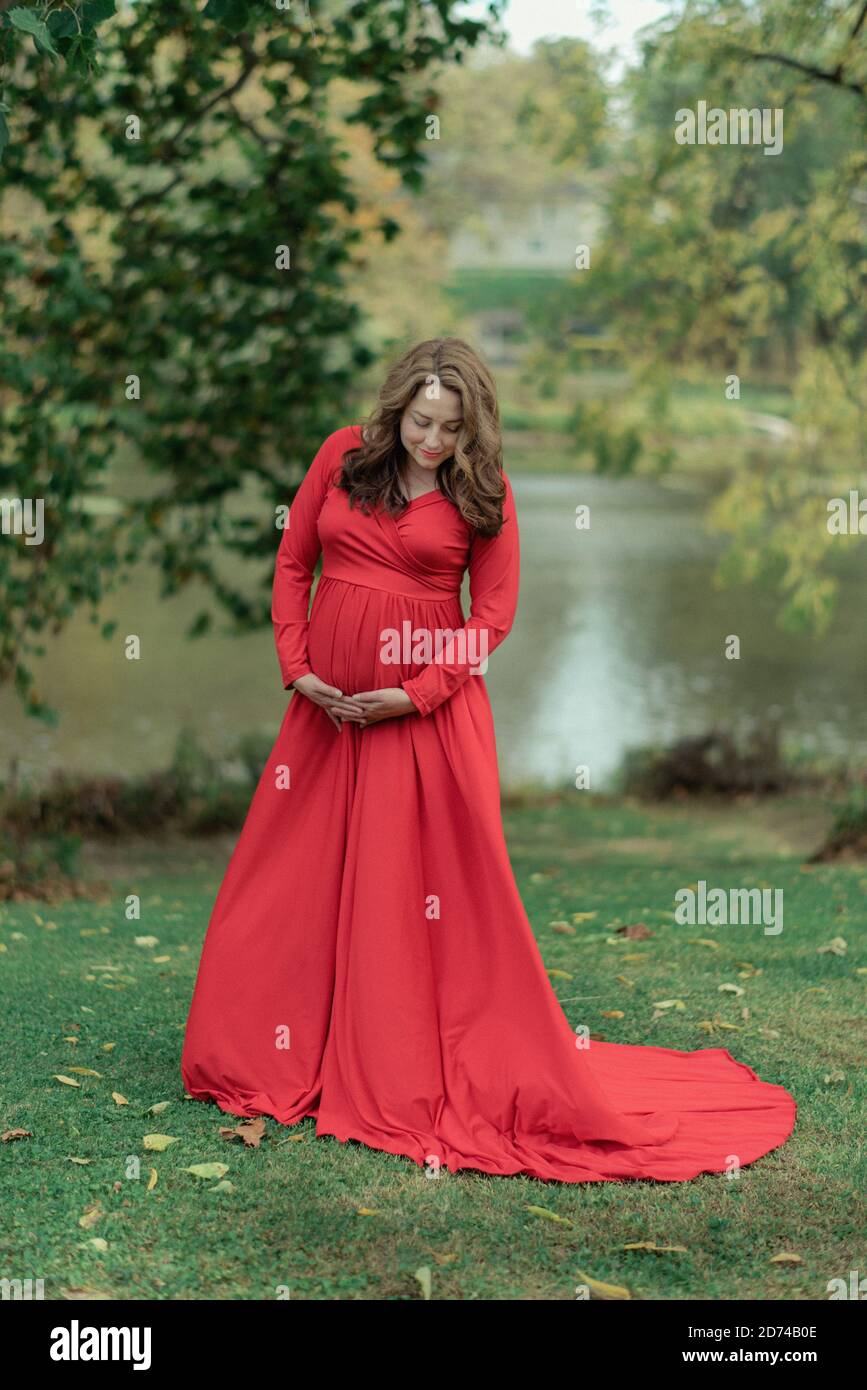 Woman in a red dress for maternity photos Stock Photo