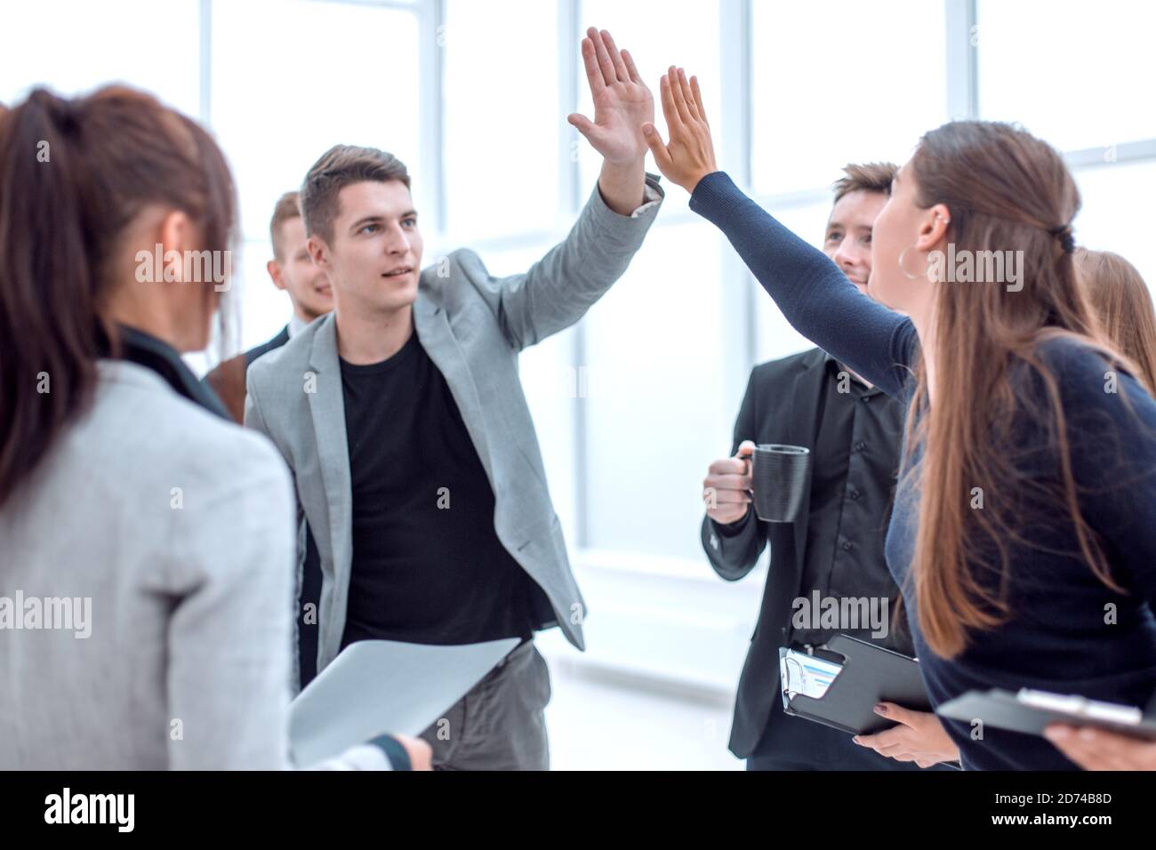 young employees giving each other a high five Stock Photo