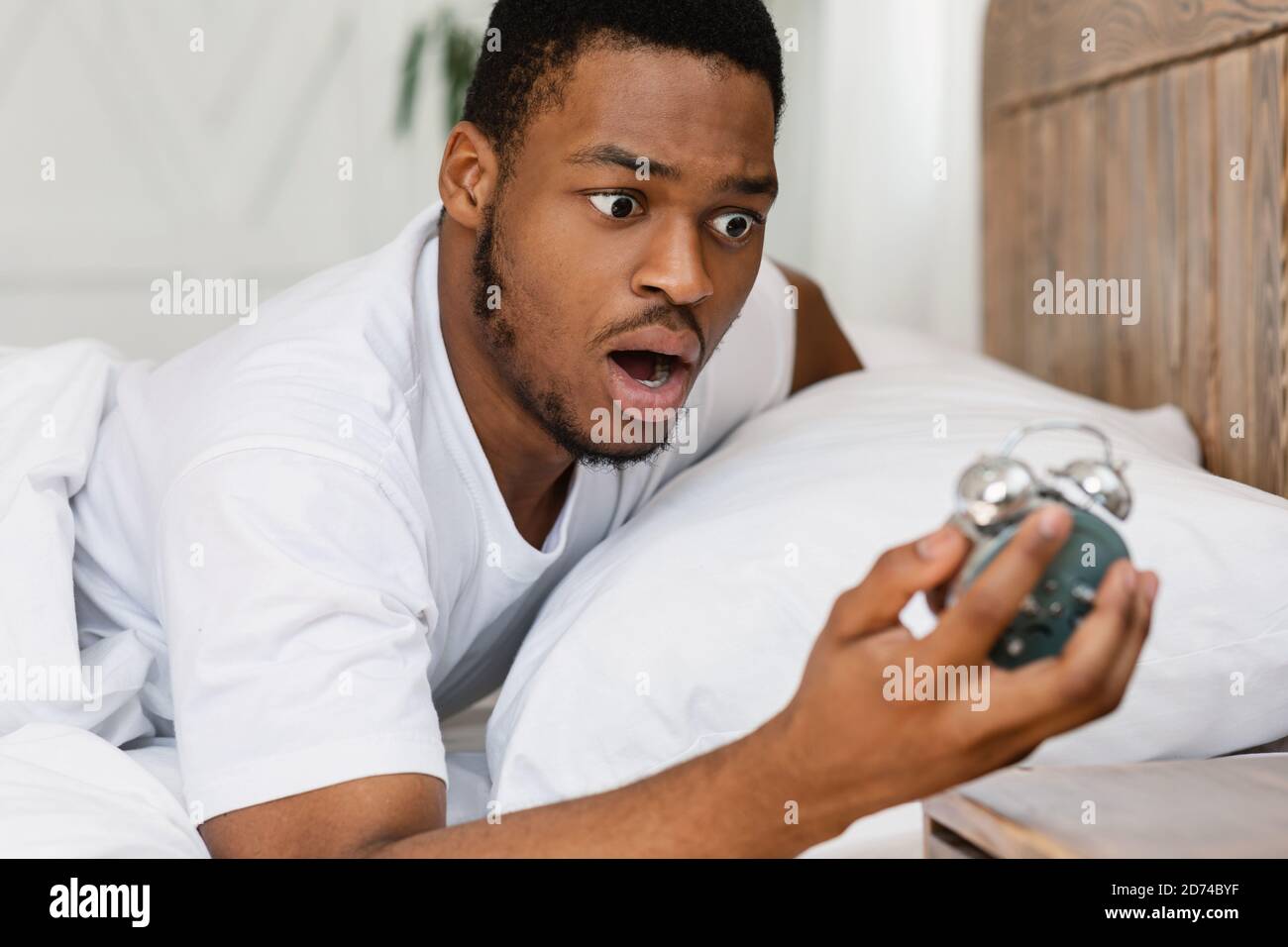 Waking up and looking at an alarm clock hires stock photography and