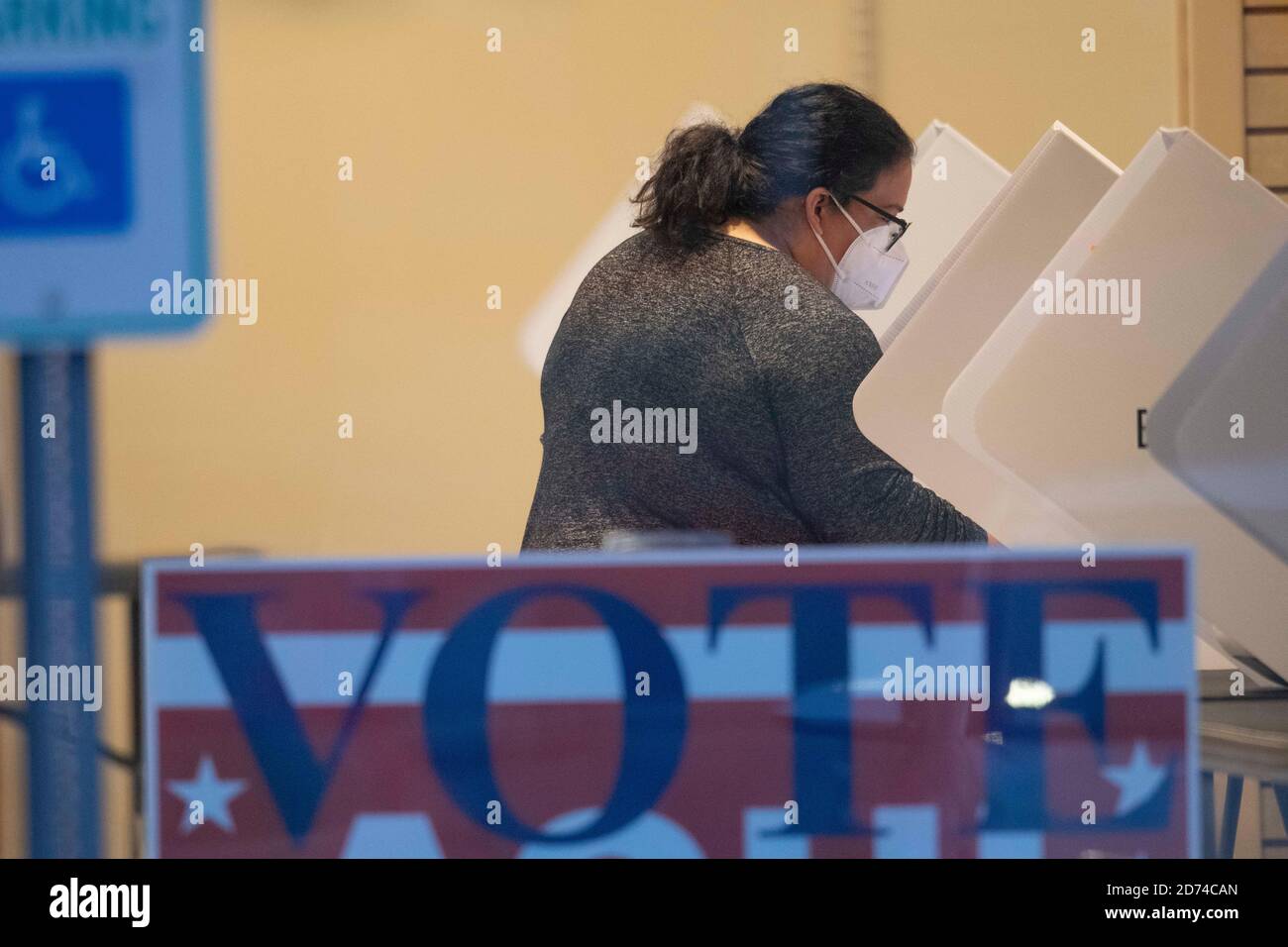 Austin, Texas October 20, 2020: A Travis County voter wearing a facemask casts her ballot at a polling place during the early voting period in Texas. The county has averaged a record 35,000 voters per day with two weeks remaining before the November 3rd election. Texans have cast more than four million ballots so far in early voting. Credit: Bob Daemmrich/Alamy Live News Stock Photo