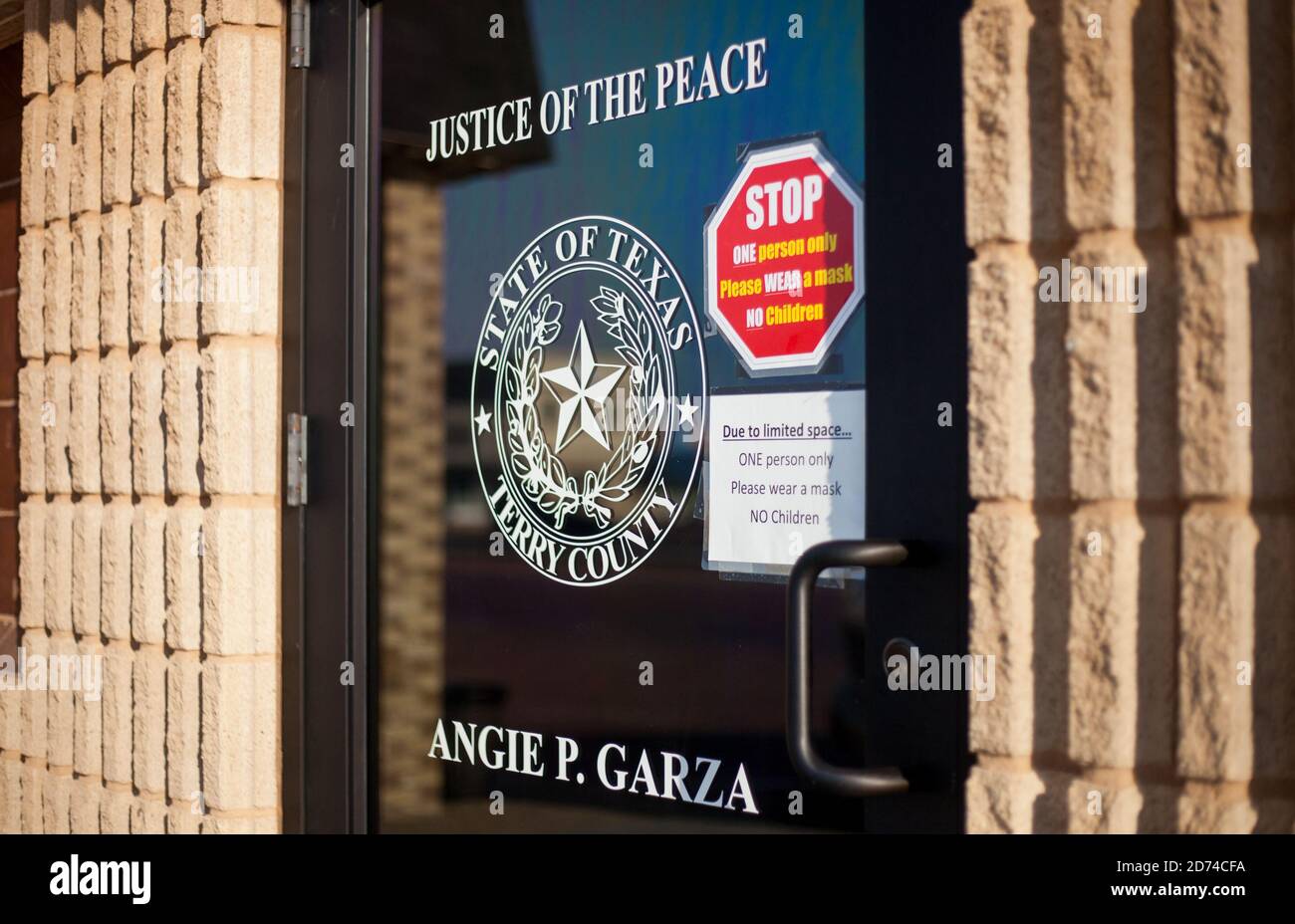 BROWNFIELD, TX - 10/09/2020 - Door entrance to Angie p. Garza Justice of Peace in Brownfield, Texas, Terry County with the seal of the State on the gl Stock Photo