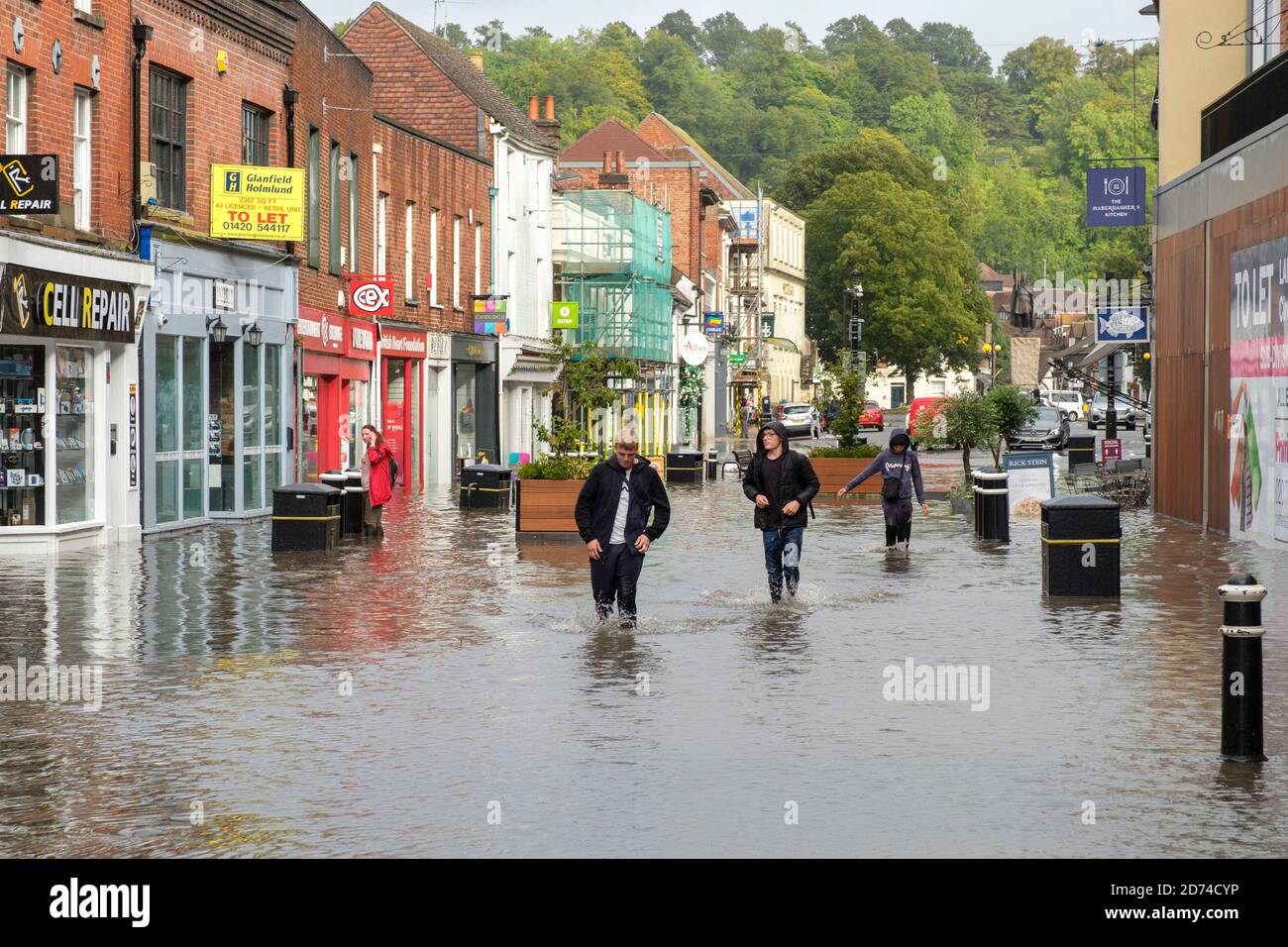 Winchester, England ,UK  27/08/2020 A group of teenagers wade through flood water on the High street in Winchester after heavy downpours due to storm Stock Photo