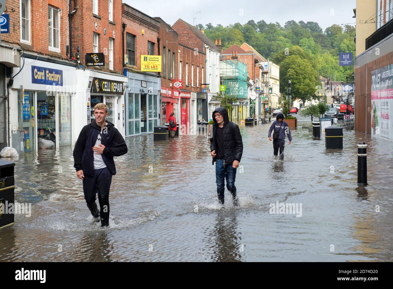 Winchester, England ,UK  27/08/2020 A group of teenagers wade through flood water on the High street in Winchester after heavy downpours due to storm Stock Photo