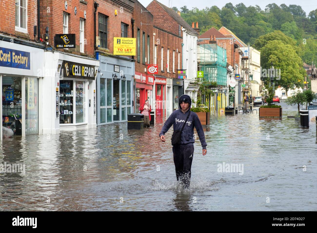 Winchester, England ,UK  27/08/2020 A teenager wades through flood water on the High street in Winchester after heavy downpours due to storm Francis. Stock Photo