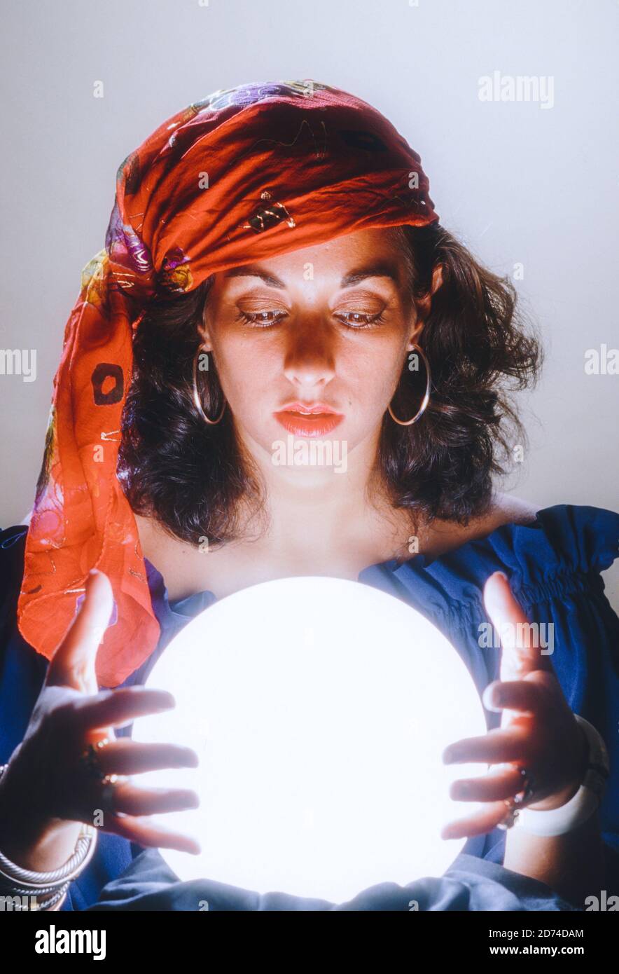 Young Woman concentrating over crystal Ball, USA Stock Photo