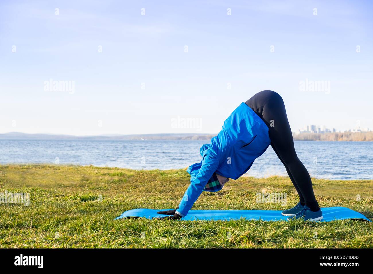 Woman doing exercise in outdoor workout in warm clothes. Stock Photo