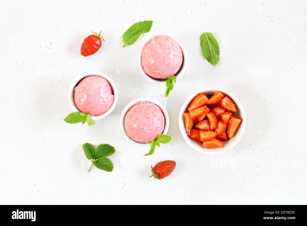 Strawberry ice cream scoop in bowl on white stone background. Top view, flat lay Stock Photo