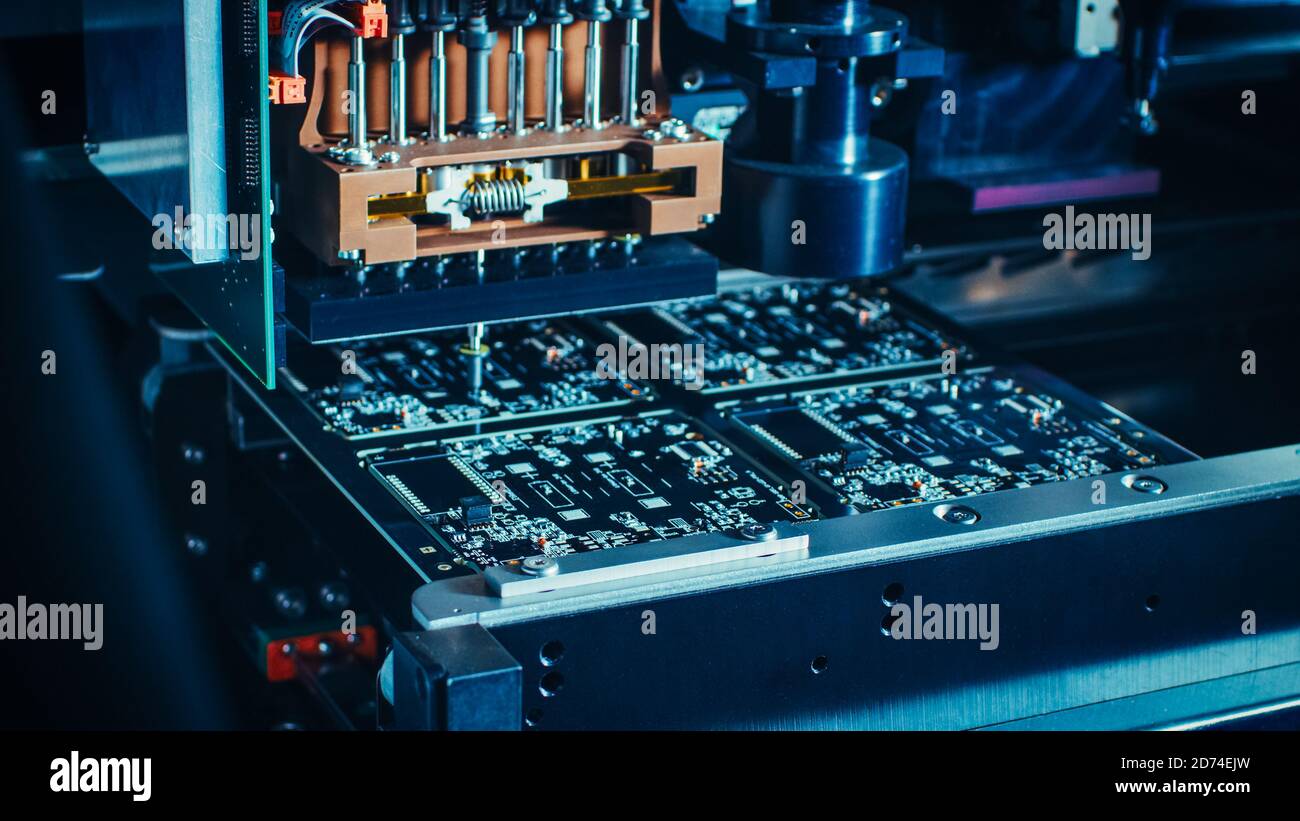 Factory Machinery at Work: Printed Circuit Board Being Assembled with Automated Robotic Arm, Pick and Place Technology Mounts Microchips to the Stock Photo