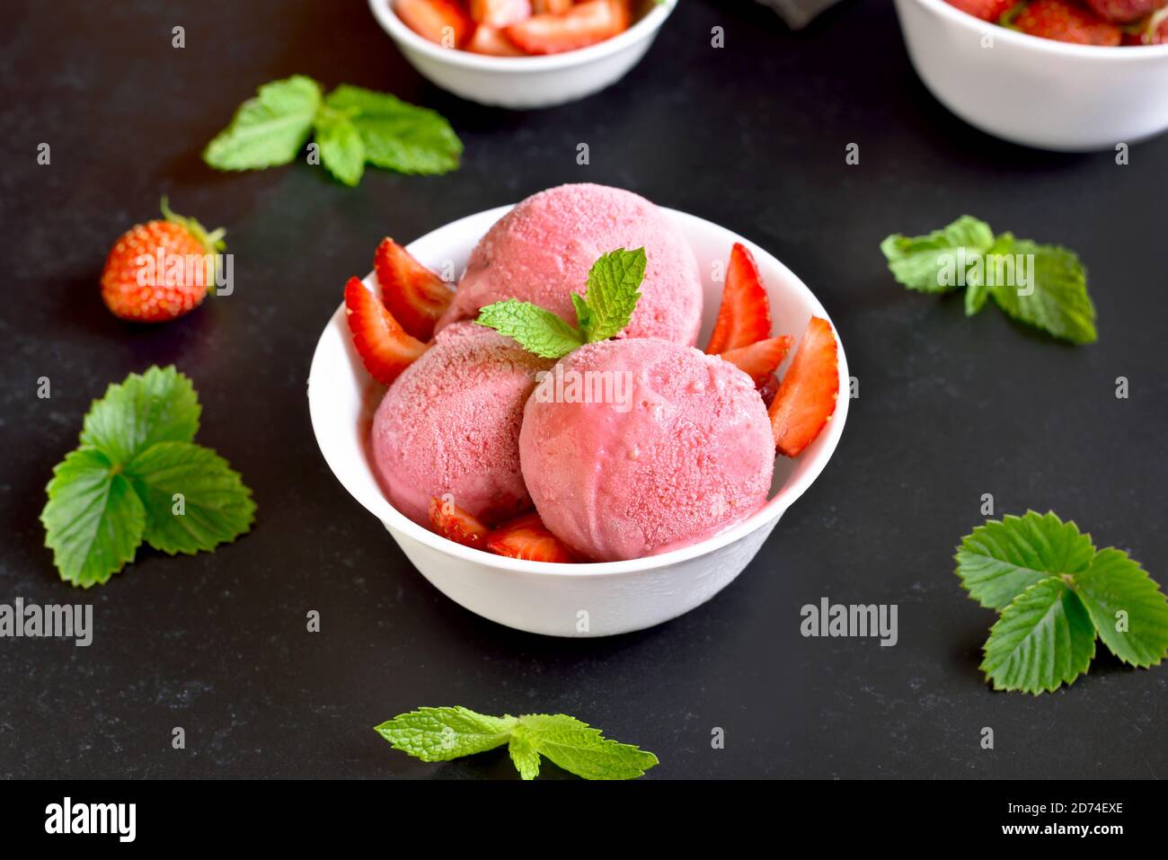 Strawberry ice cream in bowl on dark stone background. Cold summer dessert Stock Photo