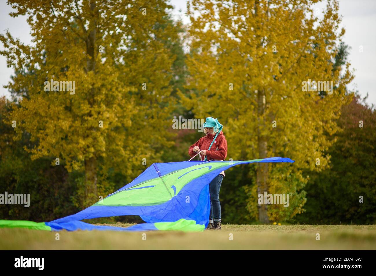 20 October 2020, Saxony-Anhalt, Magdeburg: Jaqueline Wahnschaffe from the kite friends 'Magdeburger Elbwind' prepare their kites in a green area. The kites are designed and built by the kite friends themselves. The group consists of 9 kite enthusiasts with over 500 kites. In the coming days it will be much warmer in the region around the state capital, but there will be a constant light breeze. To fly a kite you need a wind speed of at least one to three Beaufort scale wind forces. In the middle of the week the wind can be 10 kilometers per hour, which would be enough to fly a kite. Photo: Kla Stock Photo