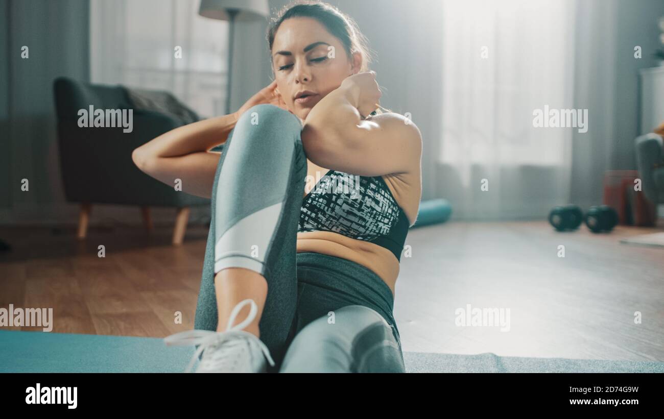 Strong and Fit Beautiful Busty Girl in an Athletic Top is Doing Crisscross  Crunch Workout in Her Bright and Spacious Living Room with Minimalistic  Stock Photo - Alamy