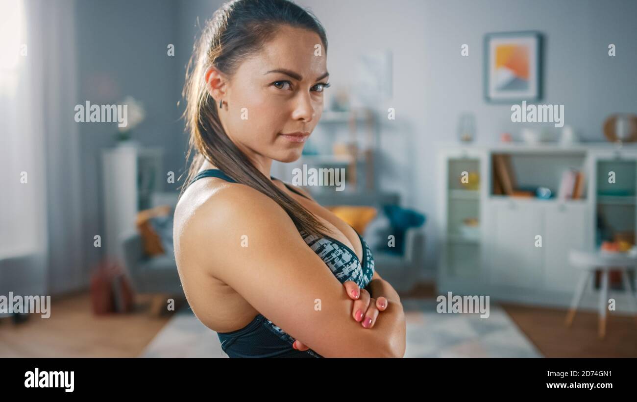 Portrait Shot of a Strong and Fit Beautiful Busty Girl in an Athletic Top  is Posing With a Soft Smile in Her Bright and Spacious Living Room with  Stock Photo - Alamy