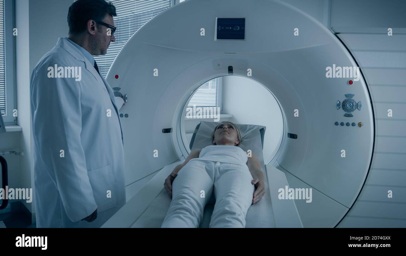 In Medical Laboratory Radiologist Controls MRI or CT or PET Scan with Female Patient Undergoing Procedure. Doctor Conducts Emergency Scanning with Stock Photo