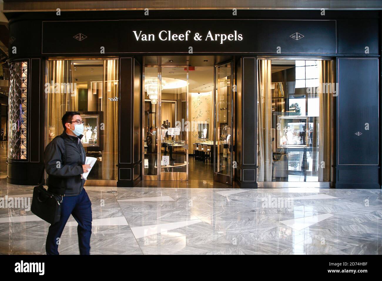 A man wearing a face mask walks past the Van Cleef & Arpels store in
