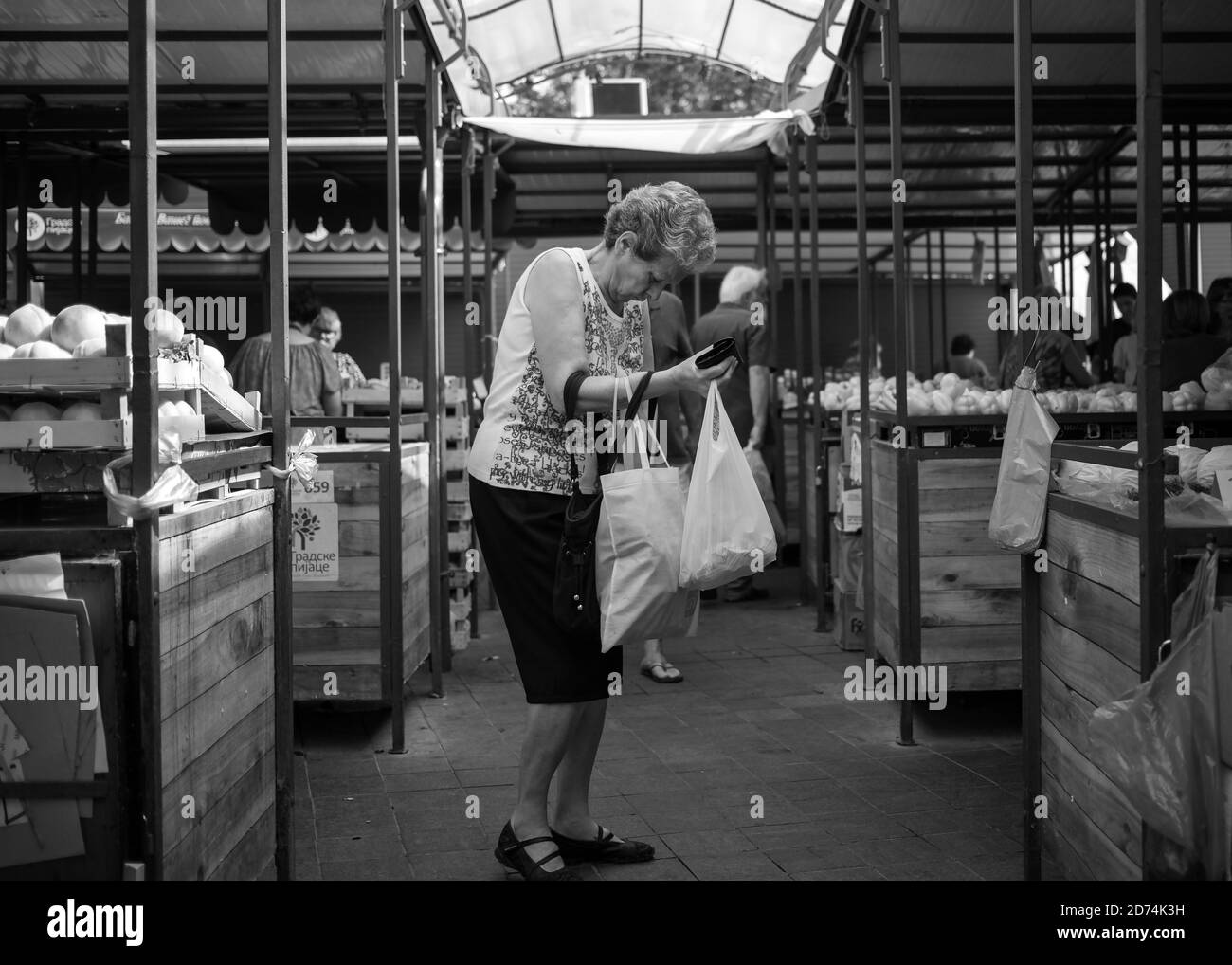 Belgrade, Serbia, Sep 12, 2019: Woman with bags at green market (B/W) Stock Photo