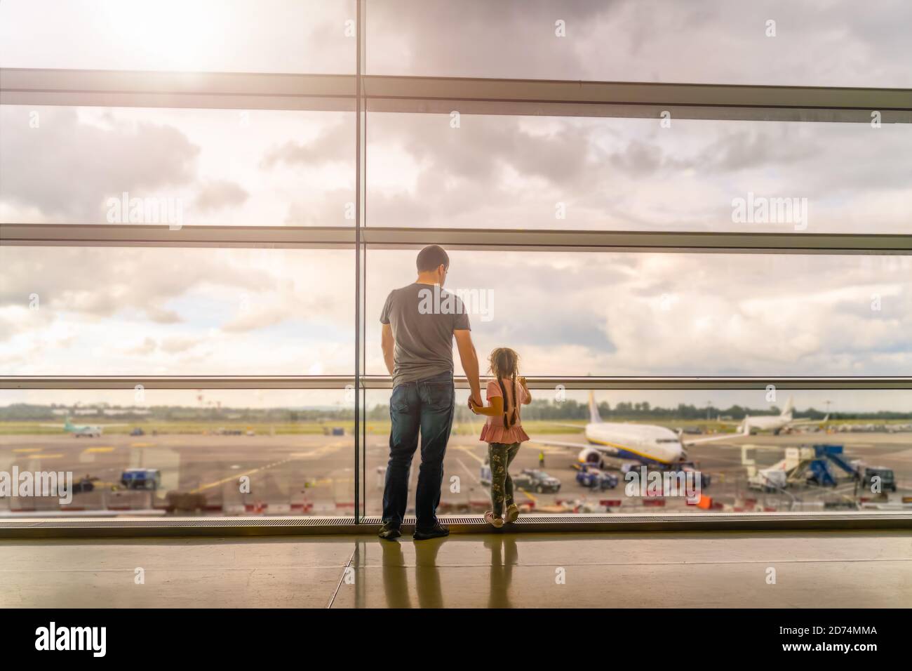 Silhouette of young family, father and daughter on airport terminal ...