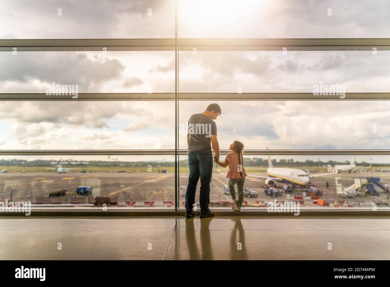 Silhouette of family, father and daughter on airport terminal. Holding ...