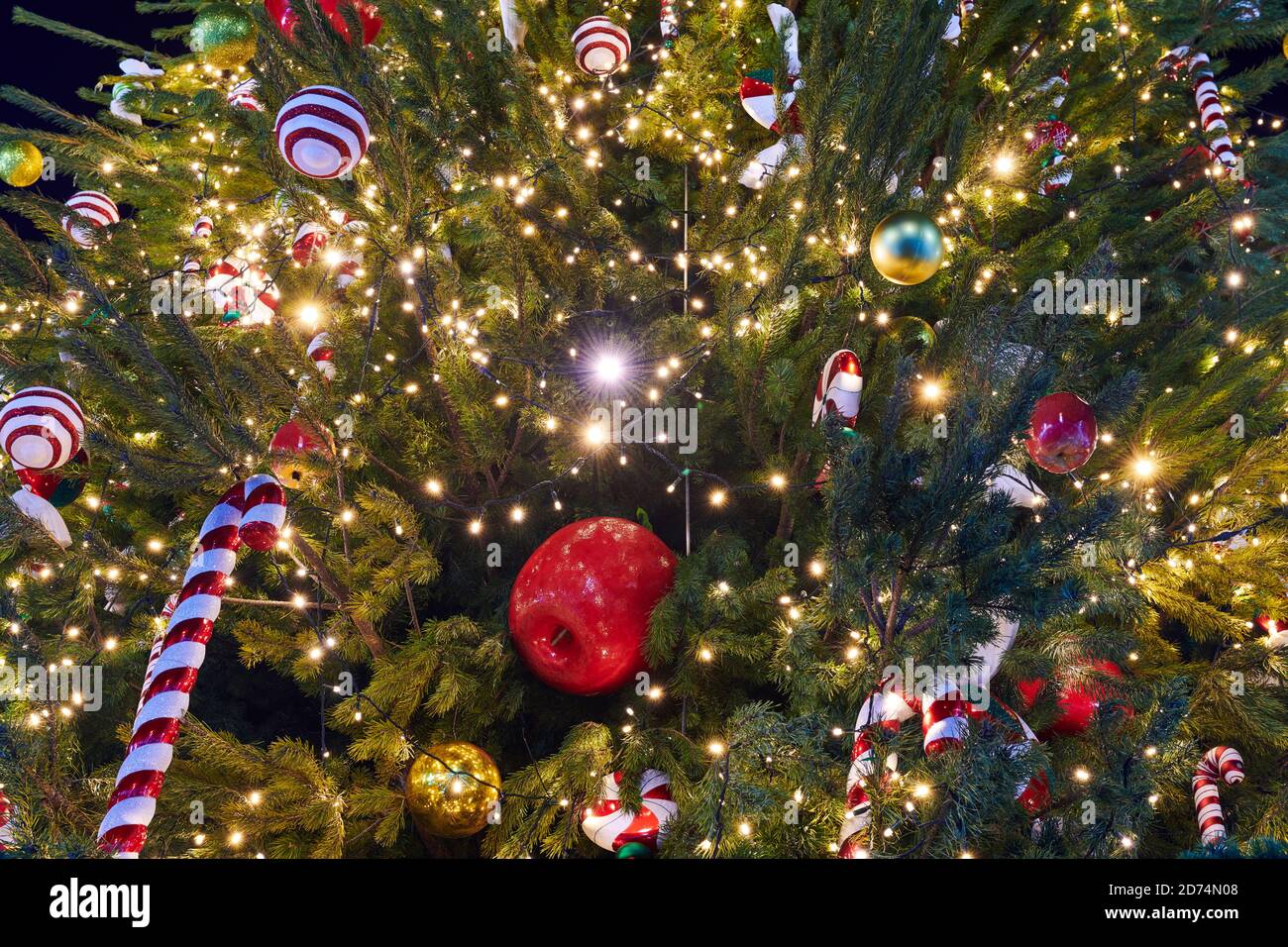 Christmas Tree decorated with garlands, Christmas candies and different baubles. New Year decorations. Closeup. Stock Photo