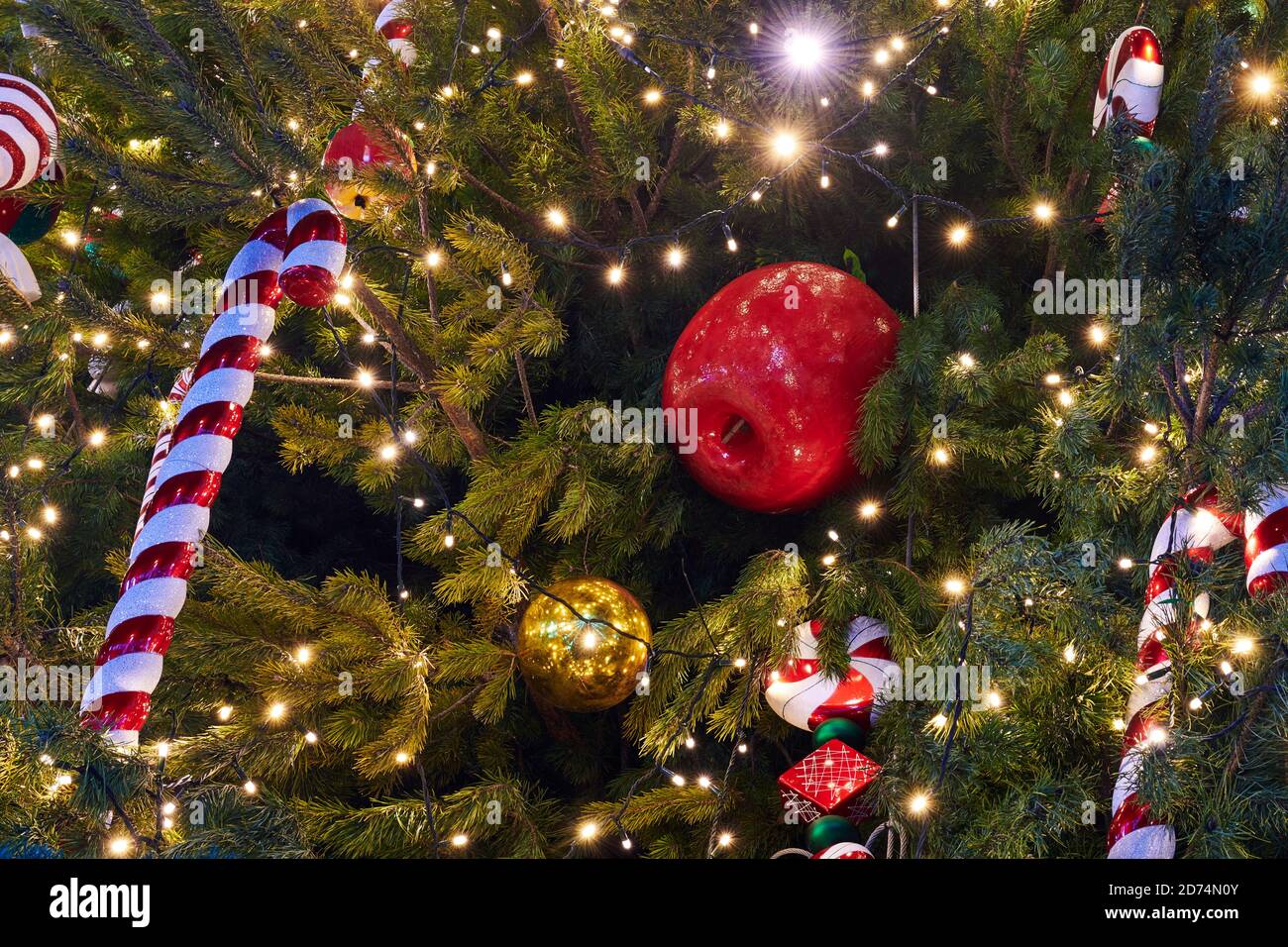 Christmas Tree decorated with garlands, Christmas candies and different baubles. New Year decorations. Closeup. Stock Photo